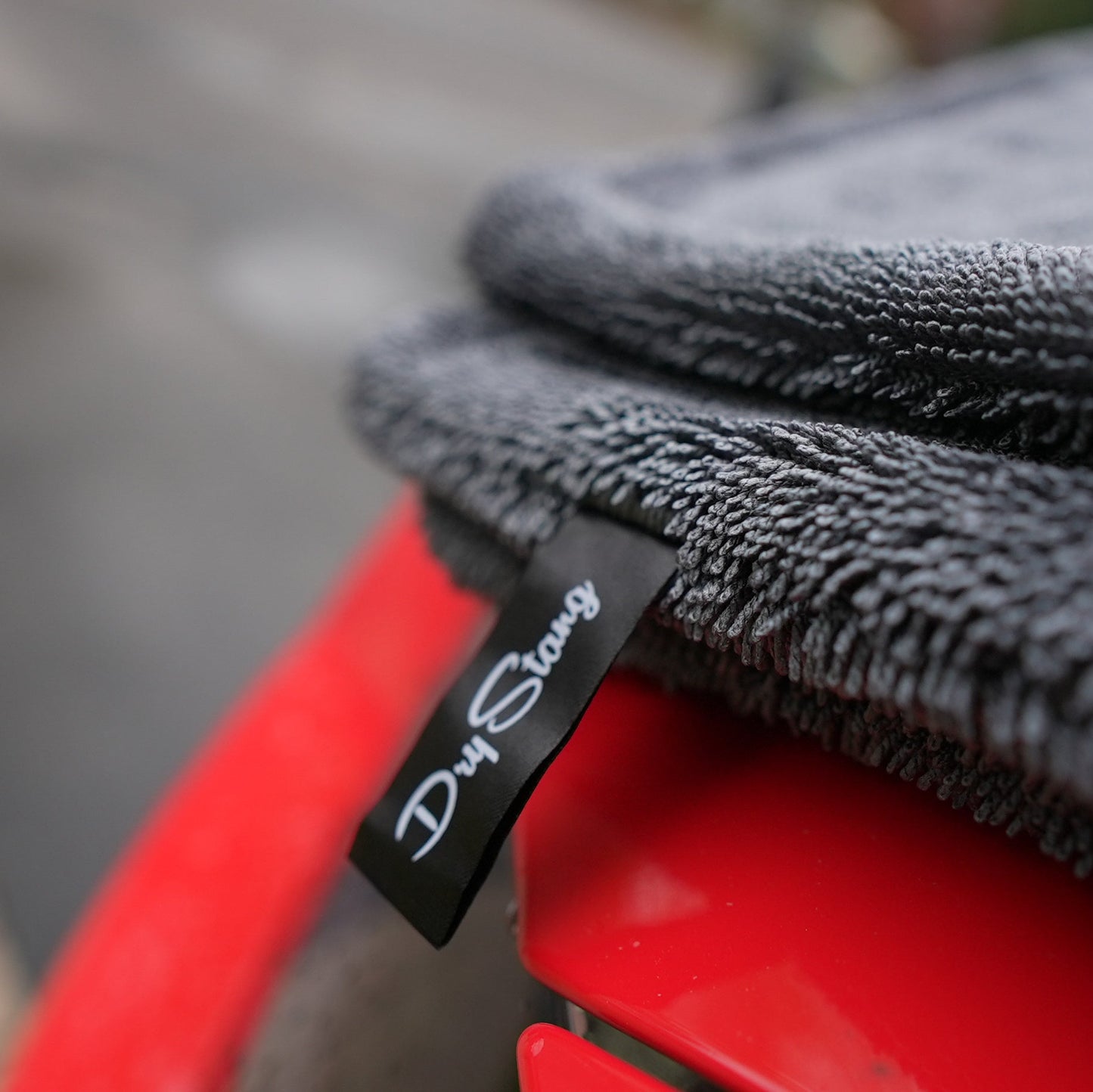 Black towel with a brand tag on a red surface