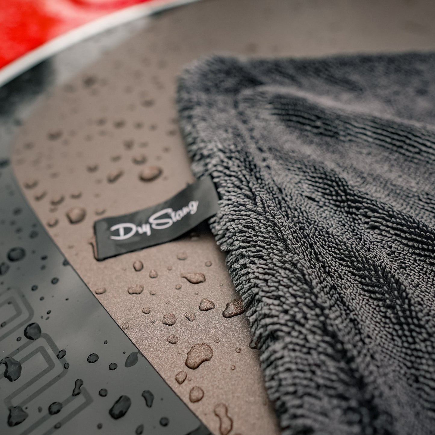 Gray microfiber towel on a car surface with 'Dry Stark' branding.