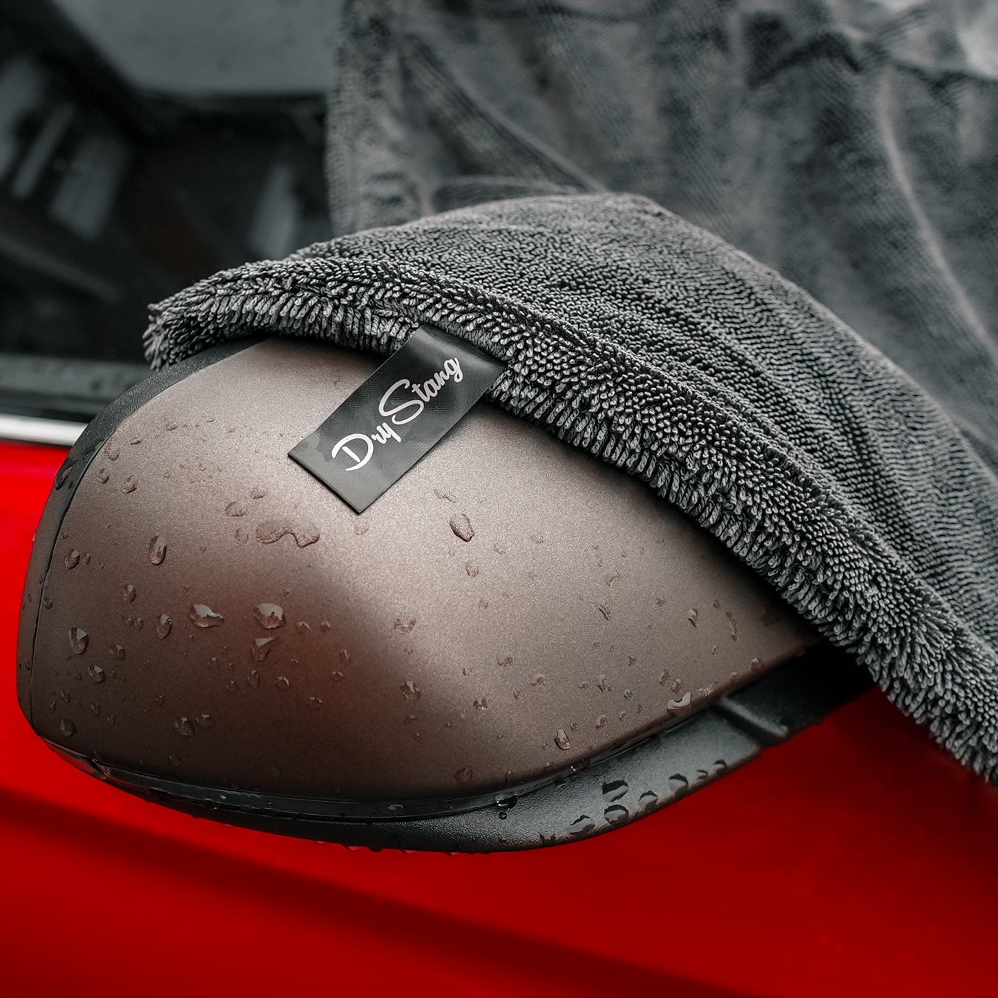 Car mirror with a gray car drying microfiber towel draped over it, featuring a 'DryStang' logo.