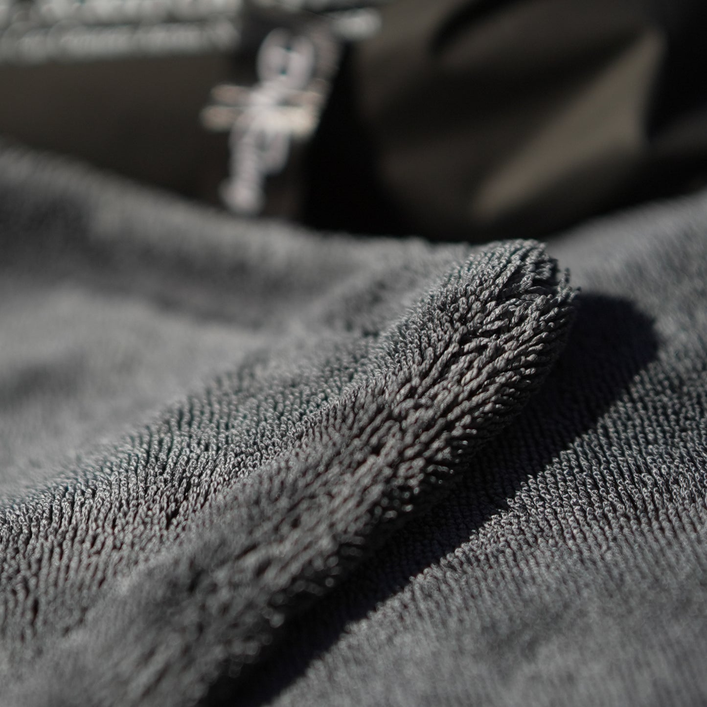 Close-up of textured gray car drying microfiber towel with a blurred background