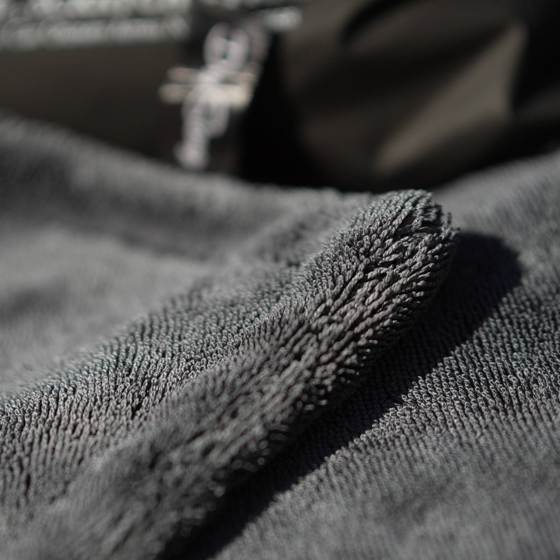 Close-up of textured gray car drying microfiber towel with a blurred background